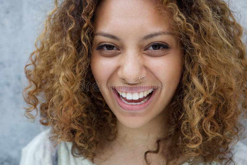 Mujer joven con la risa del pelo rizado fotografía de archivo libre de regalías Mujer joven con la risa del pelo rizado fotografía de archivo libre de regalías