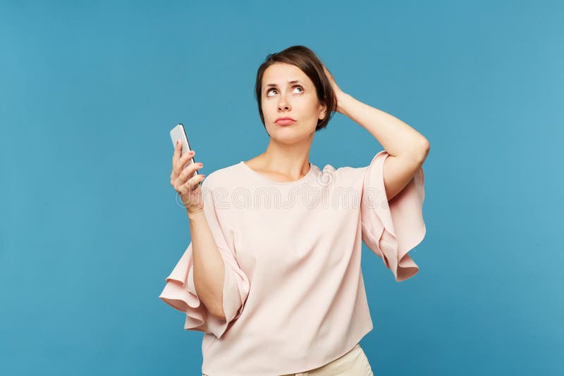 Mujer joven con smartphone que especula sobre promo fotos de archivo Mujer joven con smartphone que especula sobre promo fotos de archivo