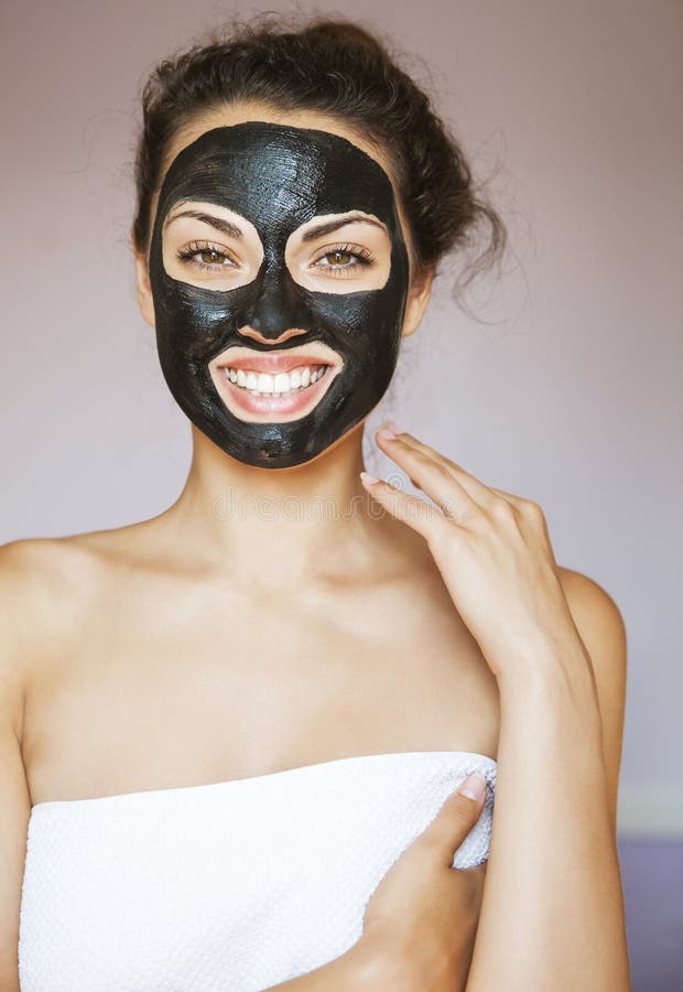 Mujer joven con una máscara para la cara del negro terapéutico MU fotos de archivo libres de regalías Mujer joven con una máscara para la cara del negro terapéutico MU fotos de archivo libres de regalías