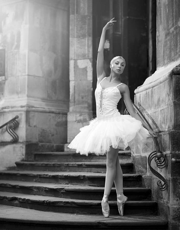 Mujer joven de la bailarina que presenta en las escaleras imagen de archivo libre de regalías Mujer joven de la bailarina que presenta en las escaleras imagen de archivo libre de regalías