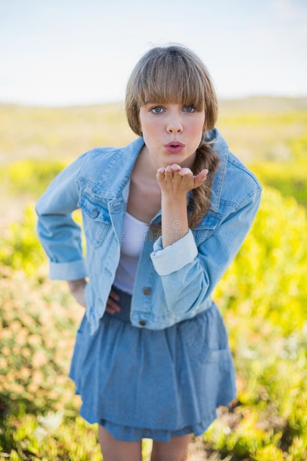 Mujer joven de moda que envía beso a la cámara fotografía de archivo Mujer joven de moda que envía beso a la cámara fotografía de archivo