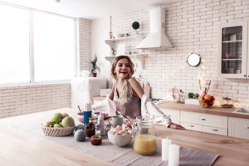 Mujer joven de pelo largo bonita y su marido oscuro-cabelludo que cocinan el desayuno junto imagen de archivo libre de regalías Mujer joven de pelo largo bonita y su marido oscuro-cabelludo que cocinan el desayuno junto imagen de archivo libre de regalías