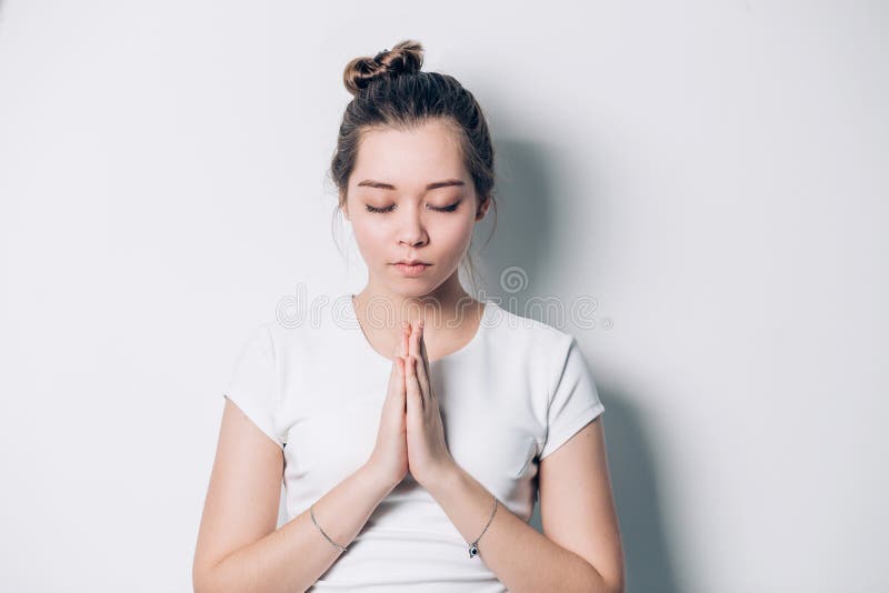 Mujer joven de rogación Hembra con las manos dobladas en el blanco que mira para arriba con una petición fotos de archivo Mujer joven de rogación Hembra con las manos dobladas en el blanco que mira para arriba con una petición fotos de archivo