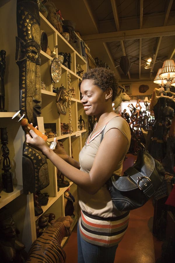 Mujer joven del afroamericano que hojea en un almacén imagenes de archivo Mujer joven del afroamericano que hojea en un almacén imagenes de archivo
