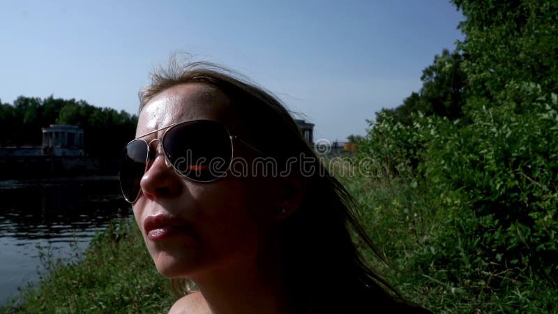 Mujer joven del retrato en gafas de sol en la playa del verano del fondo metrajes