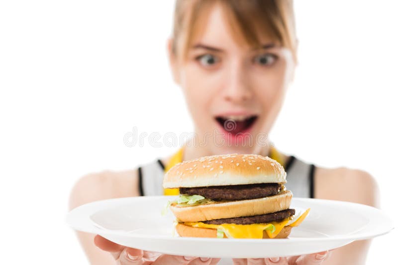 mujer joven emocionada que mira la hamburguesa en la placa fotografía de archivo mujer joven emocionada que mira la hamburguesa en la placa fotografía de archivo