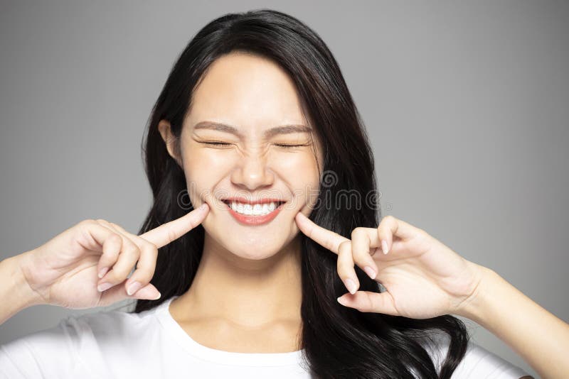 Mujer joven emocionada que muestra sus dientes foto de archivo Mujer joven emocionada que muestra sus dientes foto de archivo