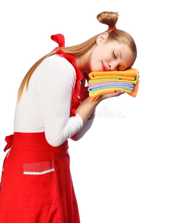 Mujer joven en delantal rojo que duerme en la pila de toallas de té coloridas foto de archivo Mujer joven en delantal rojo que duerme en la pila de toallas de té coloridas foto de archivo
