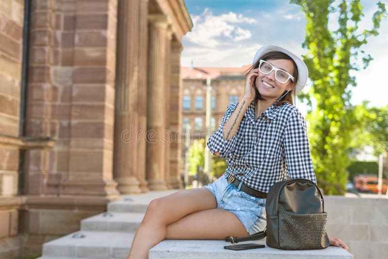 Mujer joven en la ciudad, muchacha de moda del inconformista de la sonrisa fotografía de archivo Mujer joven en la ciudad, muchacha de moda del inconformista de la sonrisa fotografía de archivo