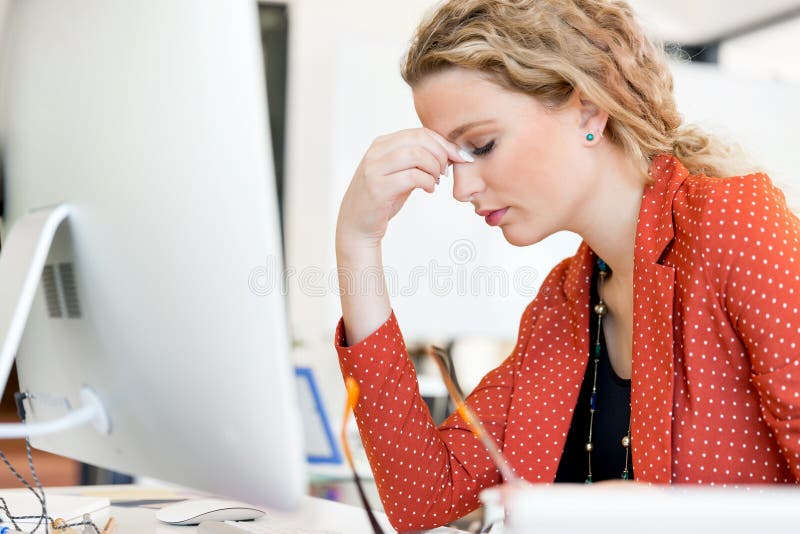 Mujer joven en la oficina cansada imagenes de archivo Mujer joven en la oficina cansada imagenes de archivo