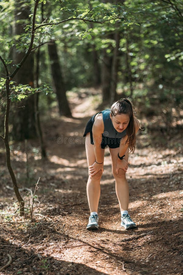 Mujer Joven En Ropa Deportiva Se Agachó Y Descansó En El Bosque