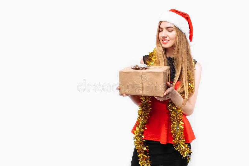 Mujer joven feliz en el sombrero y el vestido de santa, celebrando Año Nuevo foto de archivo Mujer joven feliz en el sombrero y el vestido de santa, celebrando Año Nuevo foto de archivo