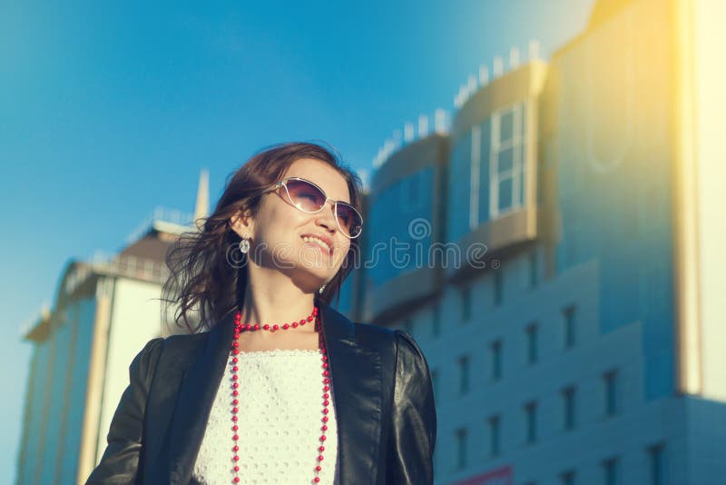 Mujer joven feliz que camina en una calle de la ciudad foto de archivo libre de regalías Mujer joven feliz que camina en una calle de la ciudad foto de archivo libre de regalías