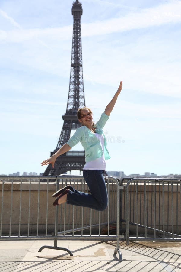 Mujer joven feliz que salta contra torre Eiffel fotografía de archivo libre de regalías Mujer joven feliz que salta contra torre Eiffel fotografía de archivo libre de regalías