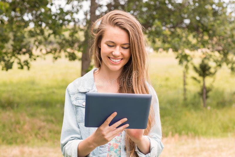 Mujer joven feliz que usa la PC de la tableta imagen de archivo Mujer joven feliz que usa la PC de la tableta imagen de archivo