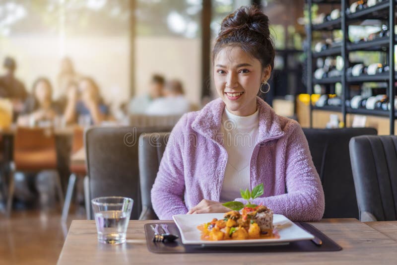 Mujer joven hermosa con la comida en restaurante foto de archivo Mujer joven hermosa con la comida en restaurante foto de archivo