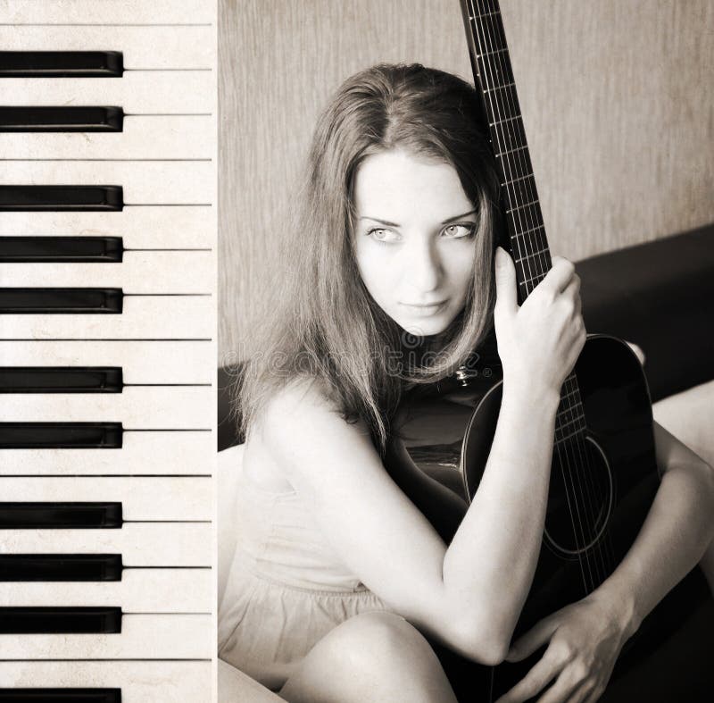 Mujer joven hermosa con la guitarra, piano foto de archivo Mujer joven hermosa con la guitarra, piano foto de archivo