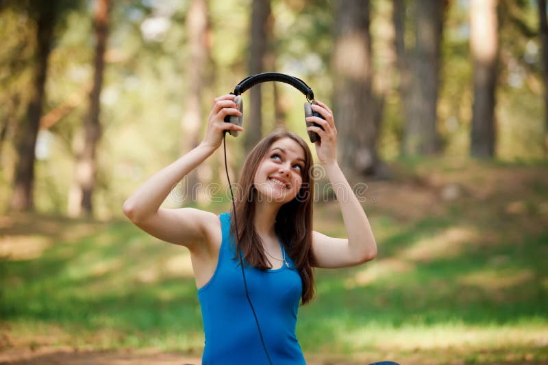 Mujer joven hermosa con los auriculares imagen de archivo libre de regalías Mujer joven hermosa con los auriculares imagen de archivo libre de regalías