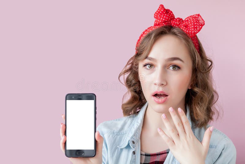 Mujer joven hermosa con maquillaje del perno-para arriba y peinado sobre fondo rosado con el tel?fono m?vil con el espacio de la fotos de archivo Mujer joven hermosa con maquillaje del perno-para arriba y peinado sobre fondo rosado con el tel?fono m?vil con el espacio de la fotos de archivo