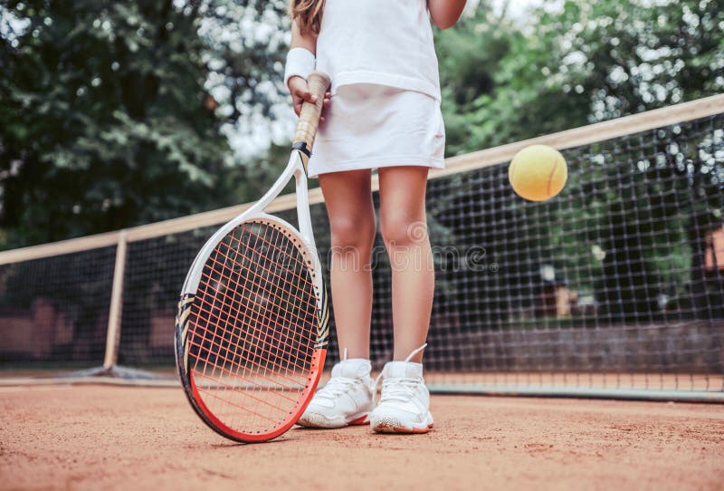 Mujer joven hermosa en desgaste del deporte que sonríe y que mira lejos foto de archivo Mujer joven hermosa en desgaste del deporte que sonríe y que mira lejos foto de archivo