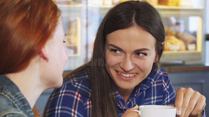 Mujer joven hermosa que come café con su amigo en la tienda de la panadería fotografía de archivo libre de regalías Mujer joven hermosa que come café con su amigo en la tienda de la panadería fotografía de archivo libre de regalías