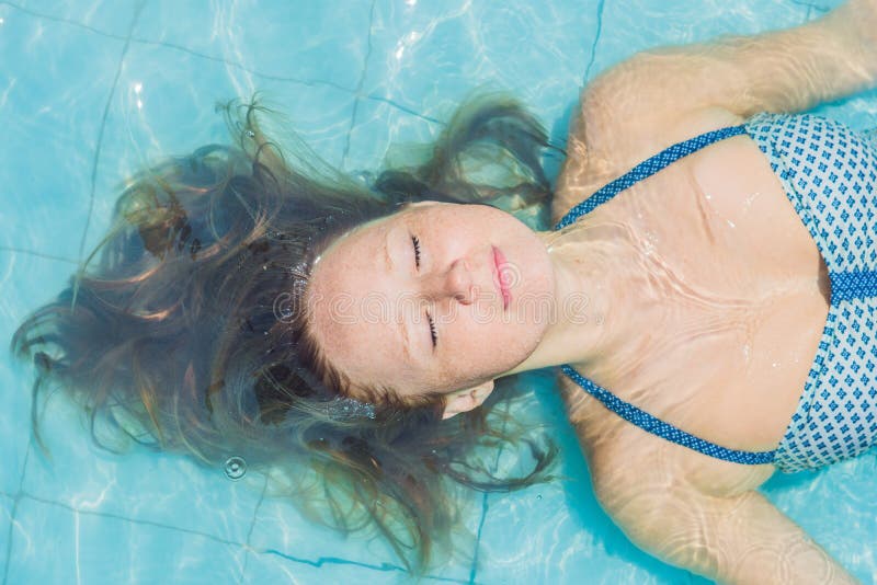 Mujer joven hermosa que flota en la opinión superior relajante de la piscina Concepto del día de fiesta fotos de archivo Mujer joven hermosa que flota en la opinión superior relajante de la piscina Concepto del día de fiesta fotos de archivo
