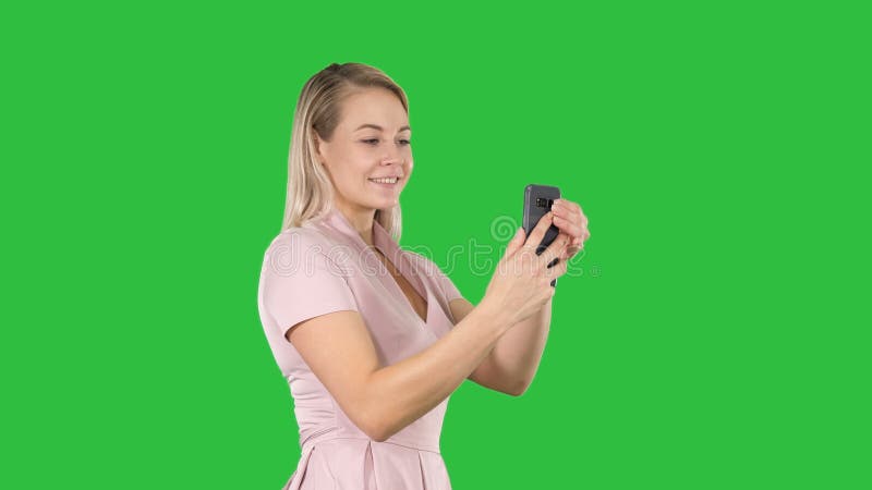 Mujer joven hermosa que hace los selfies en una pantalla verde, llave de la croma