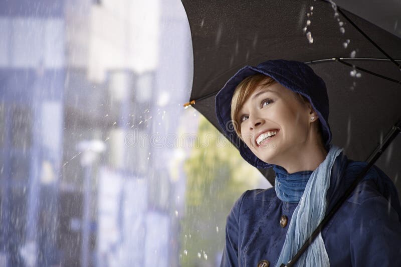 Mujer joven hermosa que sostiene el paraguas