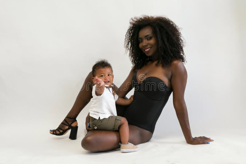 Mujer joven negra africana atractiva con el hijo pequeño Familia imagenes de archivo Mujer joven negra africana atractiva con el hijo pequeño Familia imagenes de archivo
