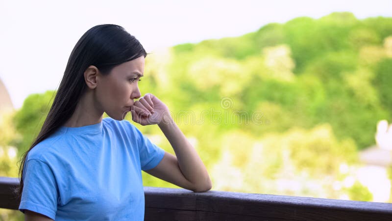 Mujer joven preocupada pensando en problemas al salir del patio trasero, ansiedad