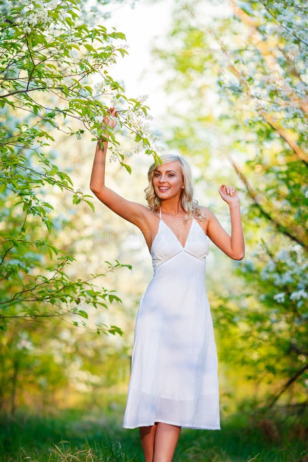 Mujer joven que camina en el jardín de la primavera imagen de archivo libre de regalías Mujer joven que camina en el jardín de la primavera imagen de archivo libre de regalías