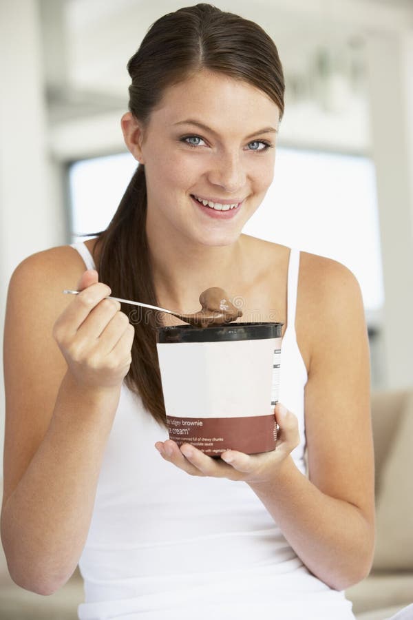 Mujer joven que come el helado del chocolate foto de archivo Mujer joven que come el helado del chocolate foto de archivo