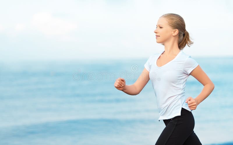 Mujer joven que corre en la playa en la costa del mar fotografía de archivo Mujer joven que corre en la playa en la costa del mar fotografía de archivo