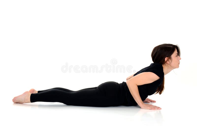 Mujer joven que hace actitud de la cobra de Bhujangasana del asana de la yoga imagen de archivo Mujer joven que hace actitud de la cobra de Bhujangasana del asana de la yoga imagen de archivo