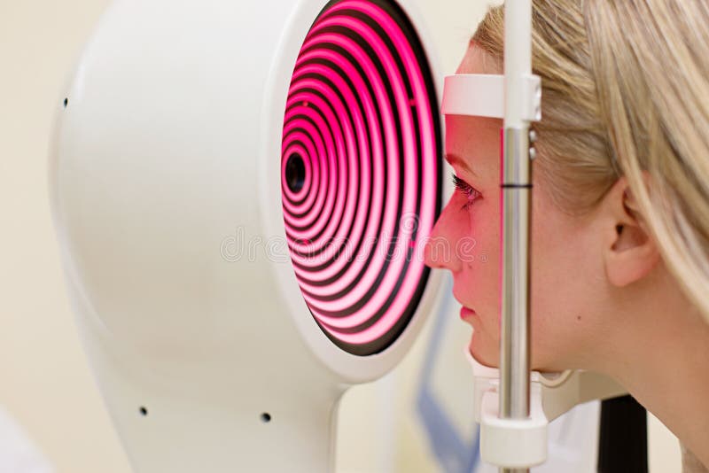 Mujer joven que la tiene ojos examinados por un ojo fotografía de archivo libre de regalías Mujer joven que la tiene ojos examinados por un ojo fotografía de archivo libre de regalías
