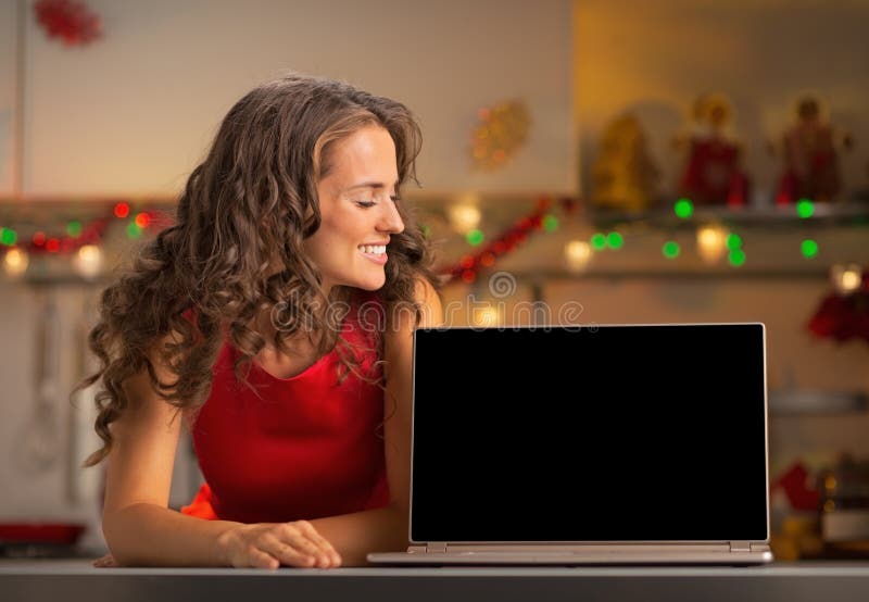 Mujer joven que muestra a ordenador portátil la pantalla en blanco imagen de archivo Mujer joven que muestra a ordenador portátil la pantalla en blanco imagen de archivo