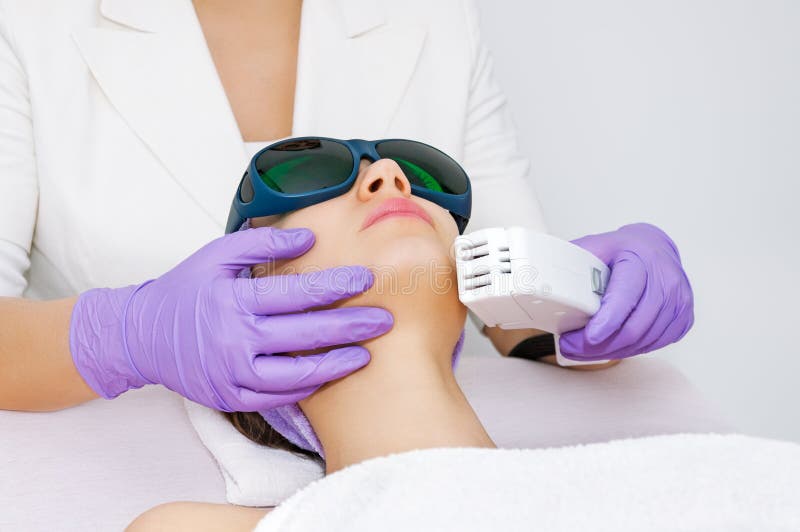 Mujer joven que recibe el tratamiento del laser del epilation fotos de archivo libres de regalías Mujer joven que recibe el tratamiento del laser del epilation fotos de archivo libres de regalías