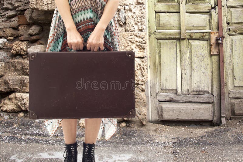 Mujer joven que se coloca con la maleta en el camino fotografía de archivo libre de regalías Mujer joven que se coloca con la maleta en el camino fotografía de archivo libre de regalías
