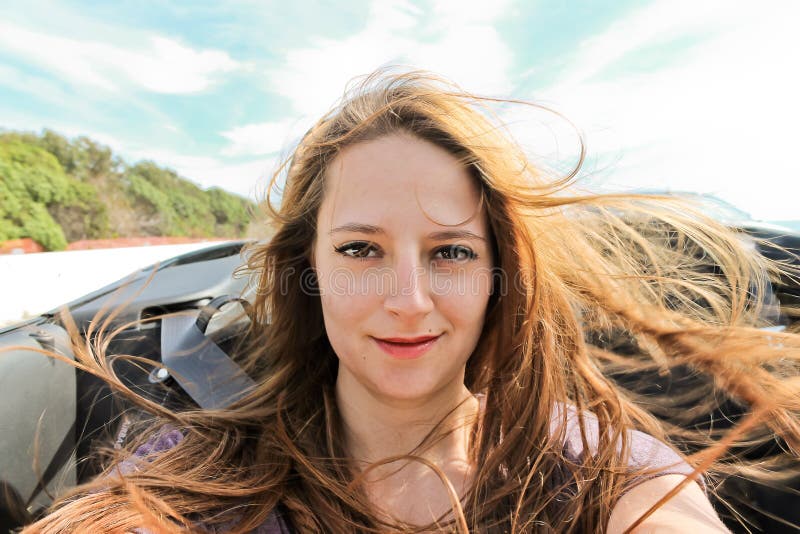 Mujer joven que toma un selfie en un convertible fotos de archivo libres de regalías