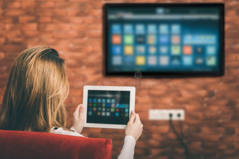 Mujer joven que ve la TV elegante foto de archivo libre de regalías