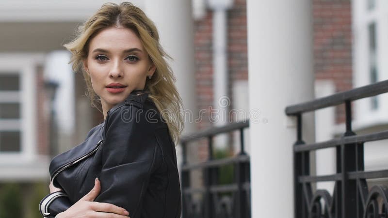 Mujer joven rubia hermosa en capa negra agradable presentación almacen de video