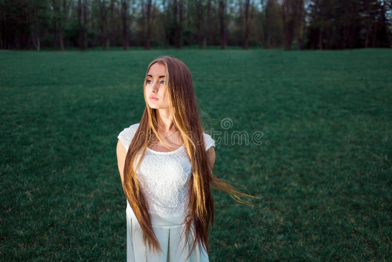 Mujer joven rubia hermosa sola en un parque místico de la tarde imagen de archivo libre de regalías Mujer joven rubia hermosa sola en un parque místico de la tarde imagen de archivo libre de regalías