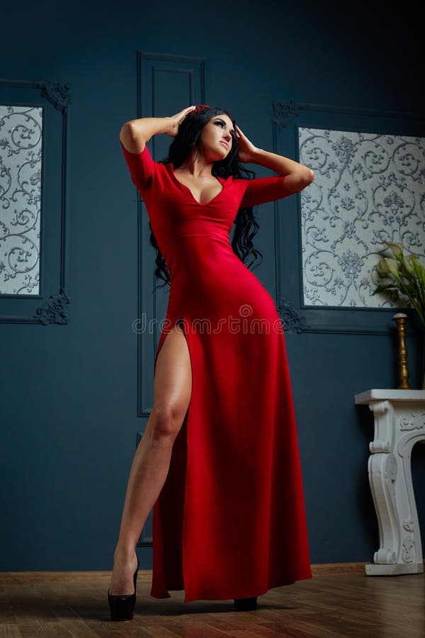 Mujer joven sensual en vestido rojo El estudio tiró de una muchacha con el pelo oscuro largo imagenes de archivo Mujer joven sensual en vestido rojo El estudio tiró de una muchacha con el pelo oscuro largo imagenes de archivo