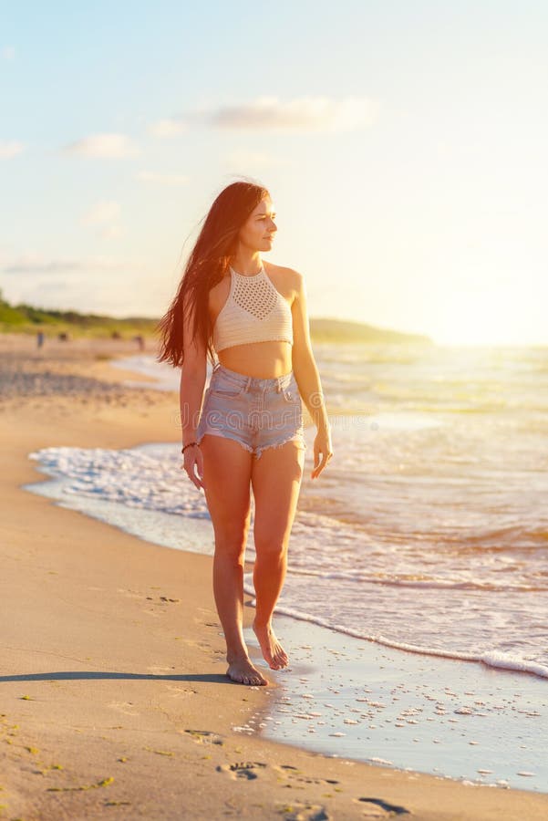 Mujer Joven Solitaria Sobre La Playa Atardecer De Sol De Playa Mujer En Moda Ropa De Playa Relajante Caminar Cerca Del O Foto archivo - Imagen de blanco, playa: 226836870