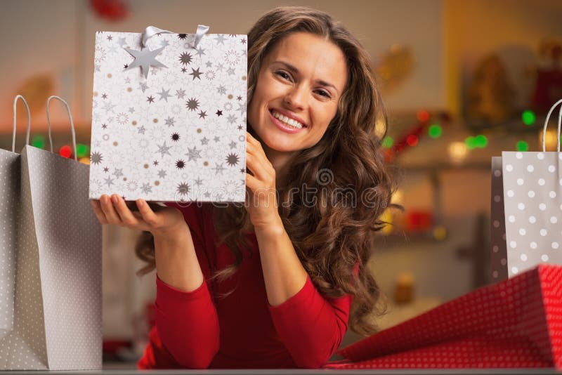Mujer joven sonriente que muestra el panier de la Navidad fotos de archivo Mujer joven sonriente que muestra el panier de la Navidad fotos de archivo