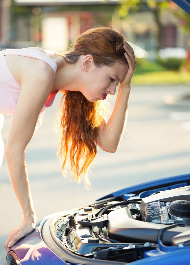 Mujer joven subrayada, enojada delante de ella coche analizado imágenes de archivo libres de regalías Mujer joven subrayada, enojada delante de ella coche analizado imágenes de archivo libres de regalías