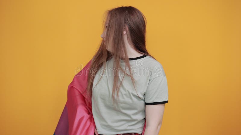 Mujer joven vestida de forma casual y cubierta con bandera bisexual