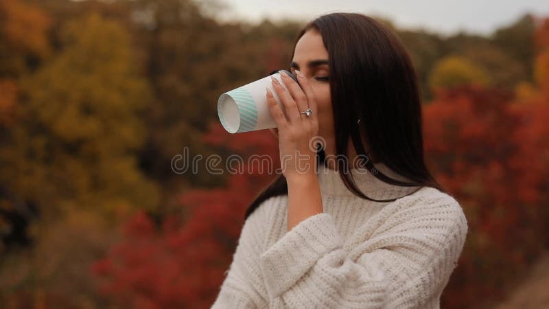 Mujer leyendo libro sentado en el bosque de otoÃ±o Mujer leyendo libro sentado en un suelo en la naturaleza tomando tÃ©, colorido