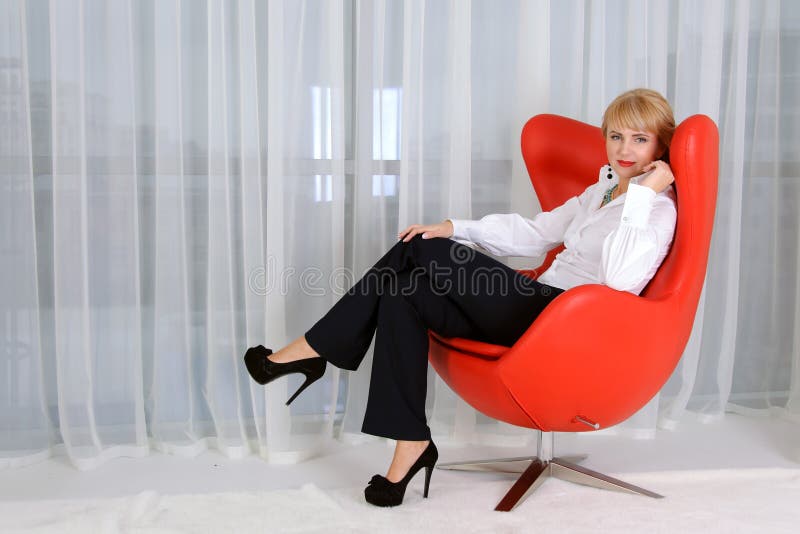 Mujer, líder, que se sienta en una silla roja fotografía de archivo libre de regalías Mujer, líder, que se sienta en una silla roja fotografía de archivo libre de regalías