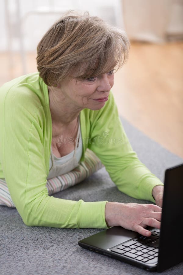 Mujer madura con la computadora portátil imágenes de archivo libres de regalías Mujer madura con la computadora portátil imágenes de archivo libres de regalías